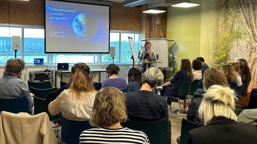 Zaal met toehoorders bij lezing over het Toekomstscenario kind/ en gezinsbescherming